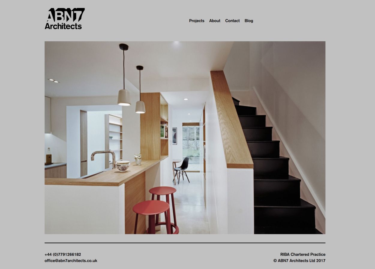 Homepage of architects ABN7 showing a modern kitchen and staircase.