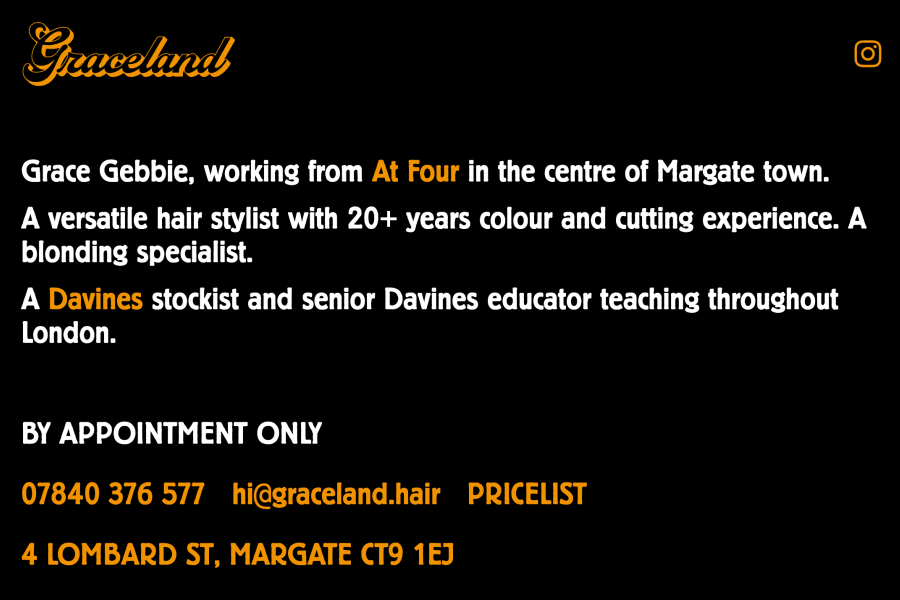 Homepage of hair salon with dark background, and white and orange text.